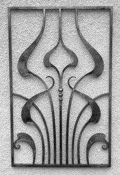 an iron gate on the side of a building with swirly designs in black and white