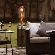 a patio heater sitting on top of a stone floor next to a table and chairs