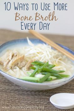 a bowl filled with noodles and green beans next to chopsticks on the table