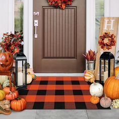 a front door decorated for halloween with pumpkins and other decorations