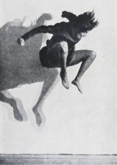 a person jumping in the air on a surfboard with their arms out and feet apart