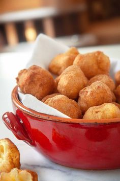 a red bowl filled with fried food on top of a table