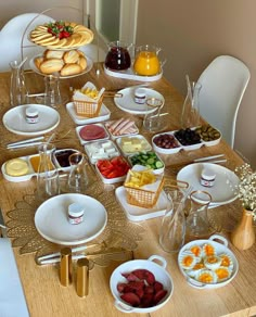 a wooden table topped with lots of plates and bowls filled with different types of food