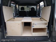 the back end of a van with its doors open and shelves in place for storage