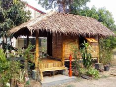 a small hut with a thatched roof and wooden steps leading to the front door