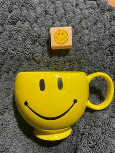 a yellow coffee cup with a smiley face on it