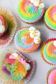 rainbow cupcakes with white frosting and sprinkles