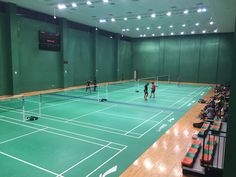 an indoor tennis court with people playing on it