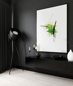 a black and white living room with an abstract painting on the wall next to it