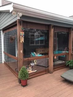 a screened porch with furniture and plants on the decking area in front of it