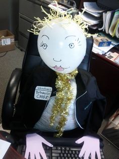 an office chair with a balloon in the shape of a man's head and hands