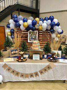 a table topped with lots of balloons and pictures next to a cake on top of a table