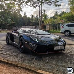 a black sports car is parked on the side of the road