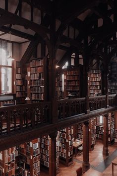 an old library with many bookshelves full of books and benches in the middle