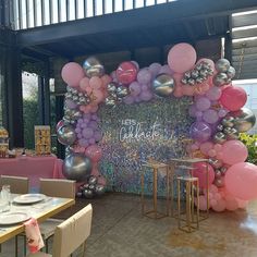 an outdoor event with balloons, tables and chairs