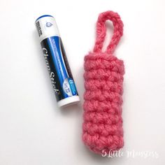 a crocheted object next to a tube of glue