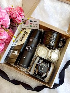 an open box containing coffee, watch and flowers