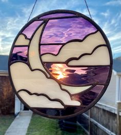 a stained glass sun catcher hanging from a chain on a house's front yard