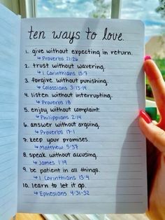 someone holding up a notebook with ten ways to love written on it