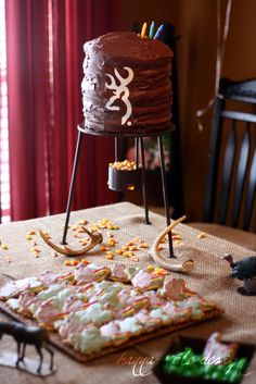 a table topped with a cake next to other items on top of a wooden table