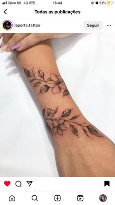 a woman's arm with flowers and leaves tattooed on the left side of her arm