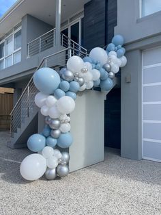 a bunch of balloons that are on the side of a building with stairs and balconies