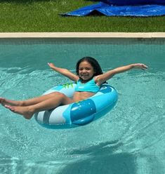 a girl in a blue and white swimsuit floating on an inflatable raft