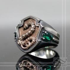 A new deluxe version of my House of the Snake Ring! It's bigger, bolder and more slithery than ever! This ring features solid sterling silver, with a detailed solid bronze snake crest, set behind the silver rim and soldered in place from the inside. Solid Sterling Silver and ancient bronze The accent stones are synthetic emeralds. Made to order in about 2 weeks. Cheers, Austin Slytherin Ring, Harry Potter Ring, Medieval Rings, Serpent Ring, The Serpent, Signet Rings, Snake Ring, The Snake, One Ring