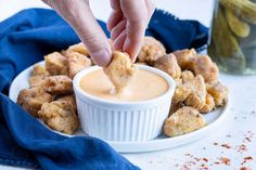 a person dipping some food into a small bowl