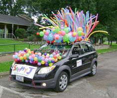 the car is decorated with balloons and streamers