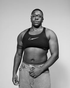 a black and white photo of a woman in a sports bra with her hands on her hips