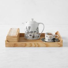 a tray with two cups and a teapot on it