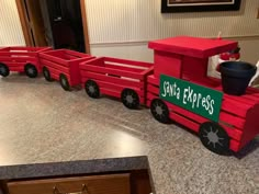 a red wooden toy train sitting on top of a counter