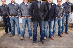 a group of men standing next to each other in front of a white barn door