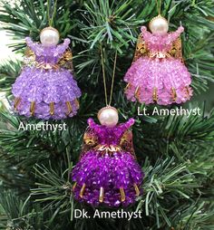 three ornaments hanging from a christmas tree with pearls on them and the names of each ornament