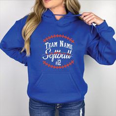 a woman wearing a blue hoodie that says team name squad on the front and number 12 on the back