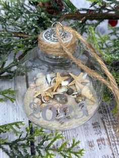 a glass ornament filled with sand and shells