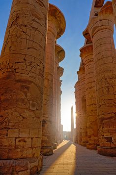 the sun is shining through some ancient columns