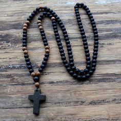 Simple, yet beautiful, this holy rosary showcases a 3 cm stone cross pendant and beautifully crafted wooden beads. The perfect rosary for a man or woman who enjoys simple and handcrafted designs. Spiritual Crucifix Necklace With 8mm Beads, Black Beads Cross Rosary Gift, Black Adjustable Crucifix Necklace, Adjustable Black Crucifix Necklace, Spiritual Rosary With 108 Beads And Crucifix, Black Cross Jewelry With 8mm Beads, Adjustable Spiritual Rosary With Cross Pendant, Black Spiritual Cross Jewelry, Spiritual Black Cross Jewelry