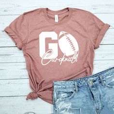 This Go Football Team shirt is the most thoughtful way to show your appreciation for your athlete friend on game day. How To Order  1. Kindly check and review all photos for your reference. 2. Choose your t-shirt size. 3. Choose your t-shirt color 4. Click add to cart when done. 5. If you need more than 1 shirt, please go back and add more. 6. Click "Proceed to check out." 7. If you have any questions, please get in touch with us. 8. Enjoy your item! 🙌Our Appreciation 🙌 We want to thank you for allowing us to serve you! We are a family owned small business, and we appreciate every opportunity we get to serve our customers. Customer satisfaction is our #1 goal. If you have any questions, please feel free to contact us. Thank you! Our Shirts ⭐Crew Neck⭐ Our crew necks are super comfy and s Team Colors Tops For Game Day, Varsity Style Tops For Football Season Game Day, Varsity Style Tops For Game Day, Team Spirit Tops For Game Day Sports Season, Collegiate Tops For Game Day During Football Season, Team-colored Tops For Game Day, Collegiate Tops For Football Season Game Day, Collegiate Tops For Football Game Day, Sporty Football Season Fan Gear Tops