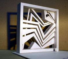 an abstract paper sculpture is displayed on a table