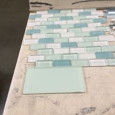 a bathroom counter with blue and white glass tiles on the top, one tile is missing