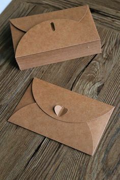 two brown envelopes sitting on top of a wooden table