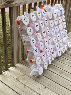 a bunch of bags that have been made to look like ghost faces on the side of a wooden deck