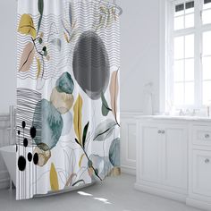 a bathroom with a shower curtain that has an image of flowers on it and leaves in the background