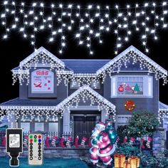 a house with christmas lights and decorations on the front yard, along with remote controls