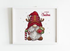 a cross stitch christmas card with a santa clause holding a candy cane and wearing a red hat