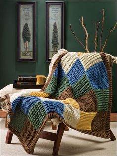 a crocheted blanket sitting on top of a wooden chair next to a table