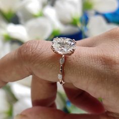 a close up of a person's hand holding a ring with a diamond on it