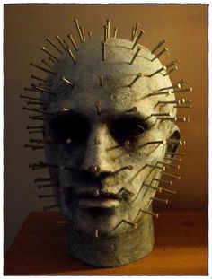 a white mask with spikes on it's head sitting on top of a table